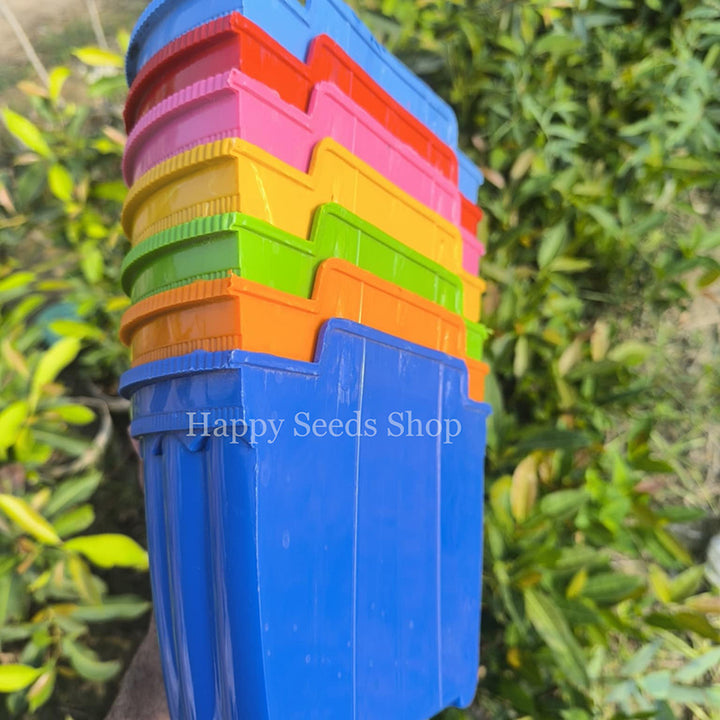Stack of colorful plastic wall pots with a blurred green background
